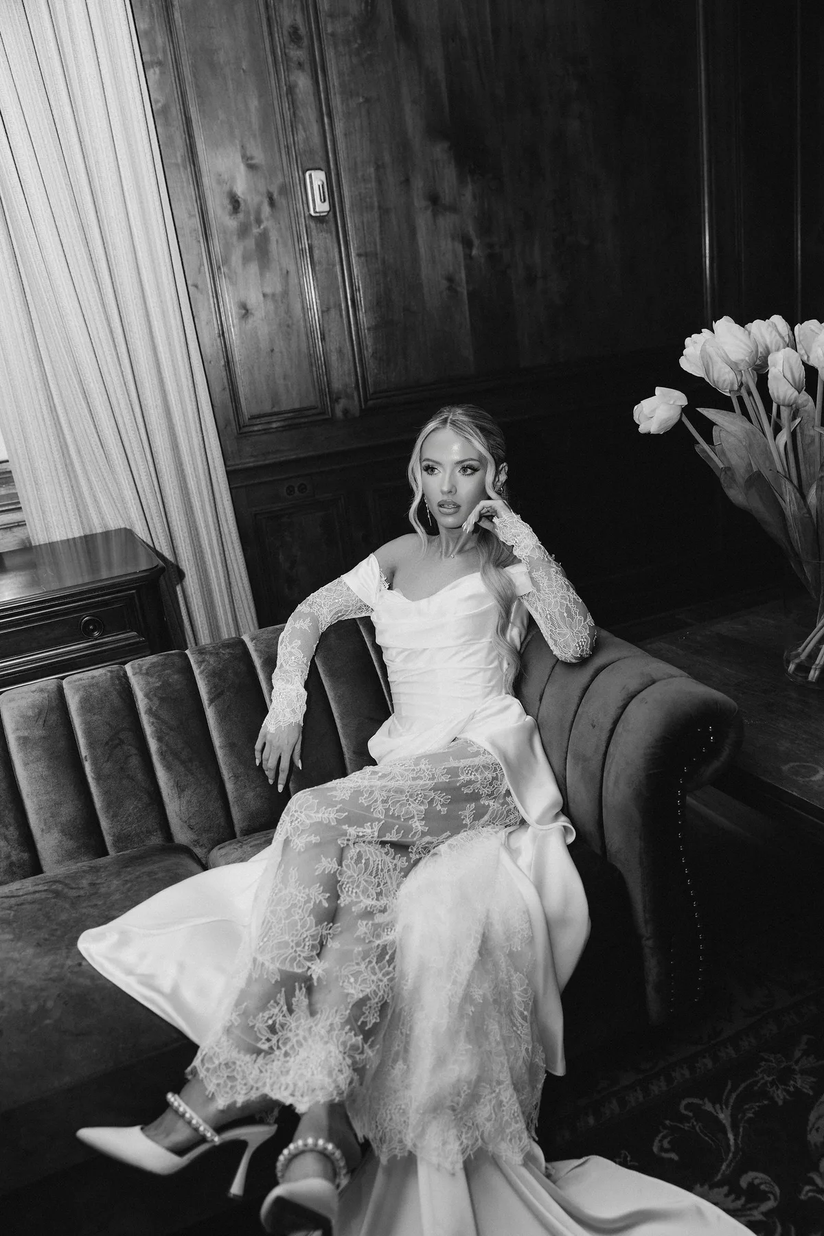 The bride seated on the sofa, her shoes off, flowers beside her