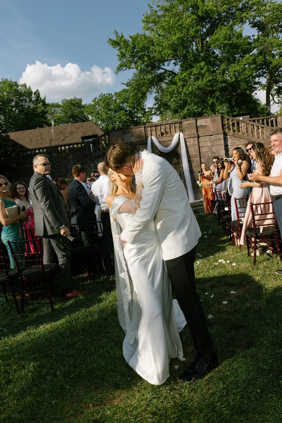 The first kiss at the end of the aisle, guests filming from their seats