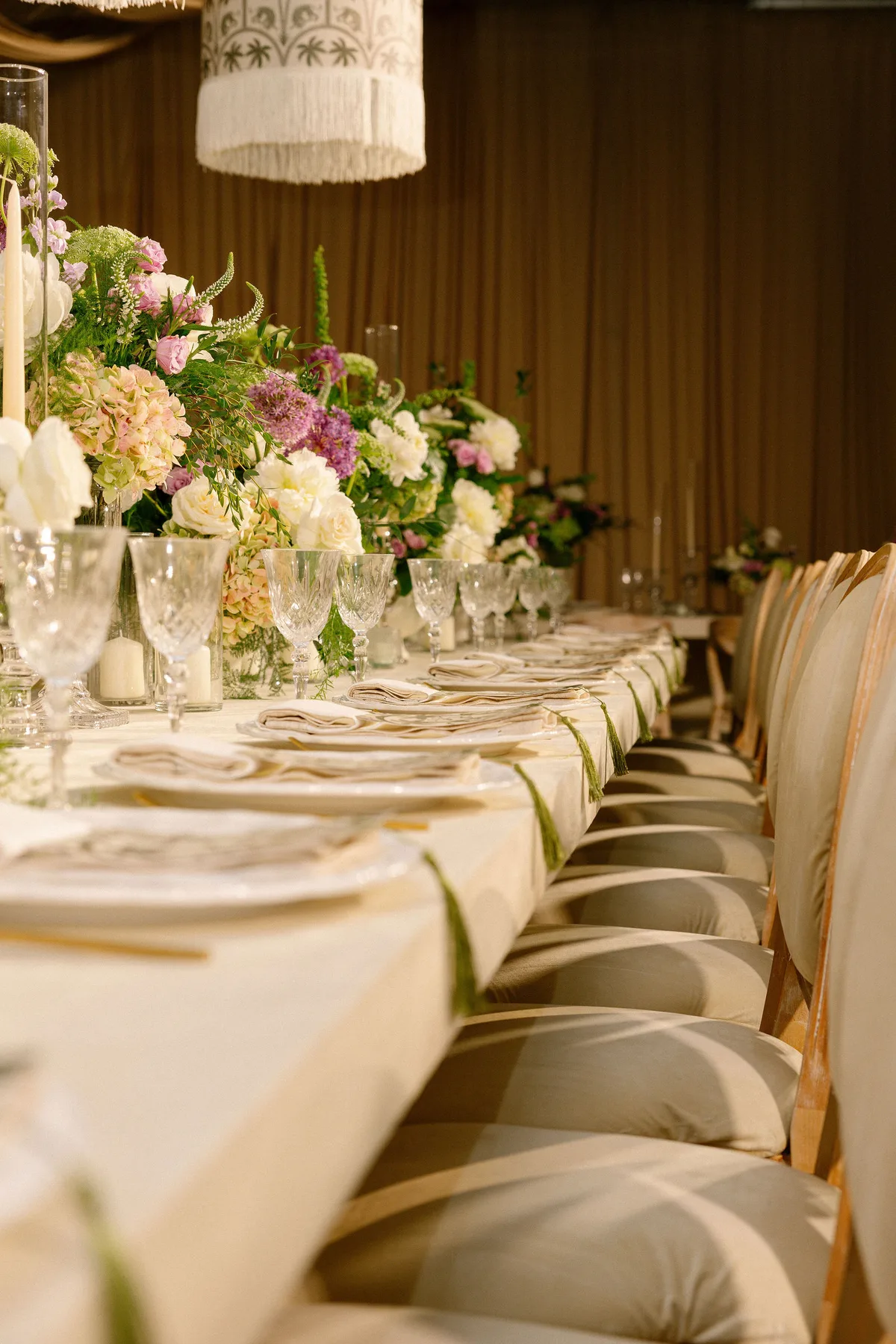 The length of a long table, candles and flowers running down it