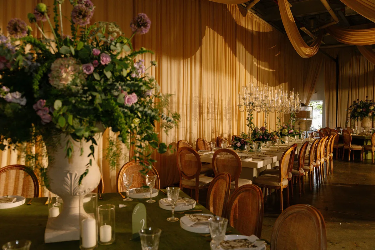 The dining room under draped fabric, a tall arrangement in the foreground
