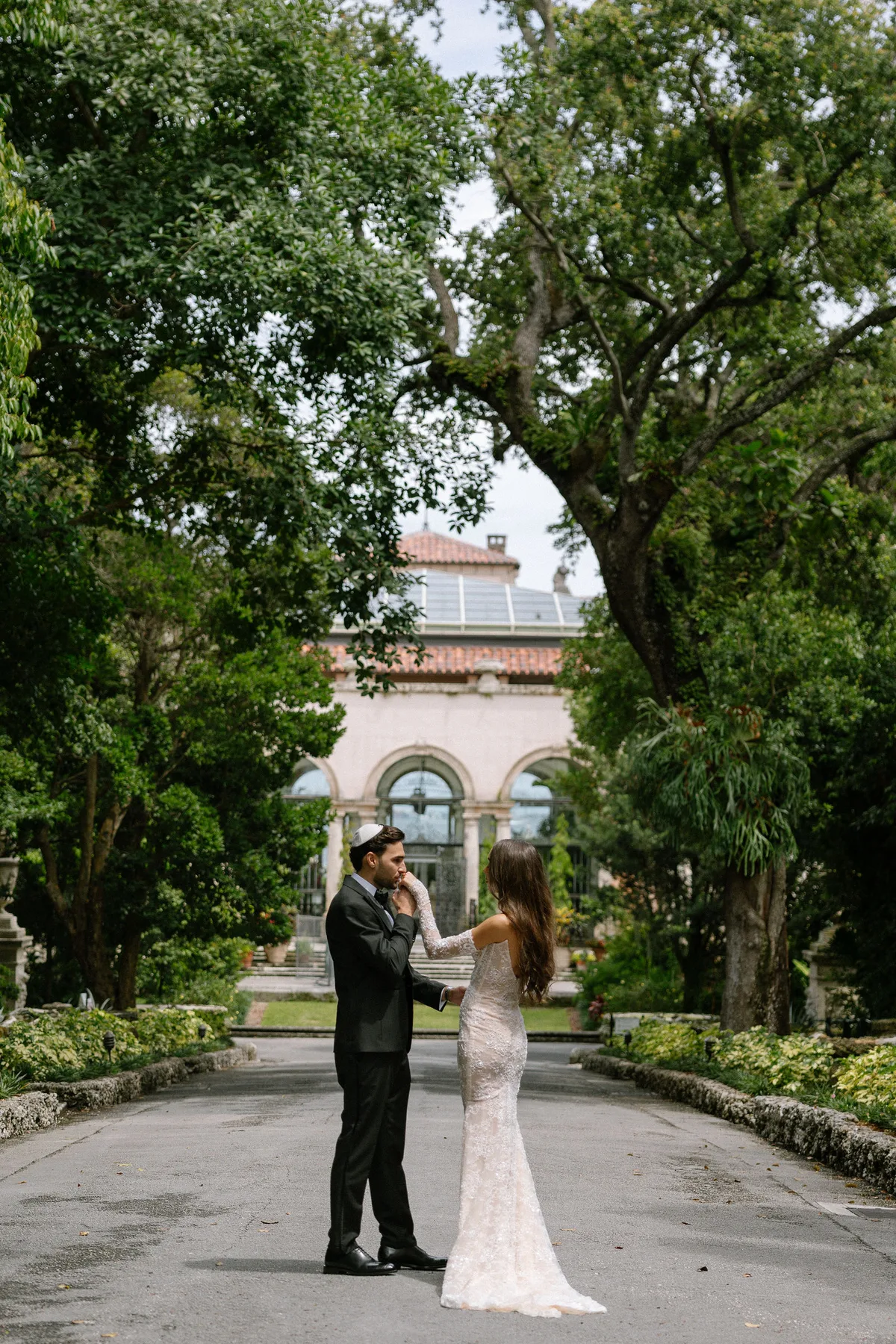 The couple on the drive before an Italianate house, trees overhead