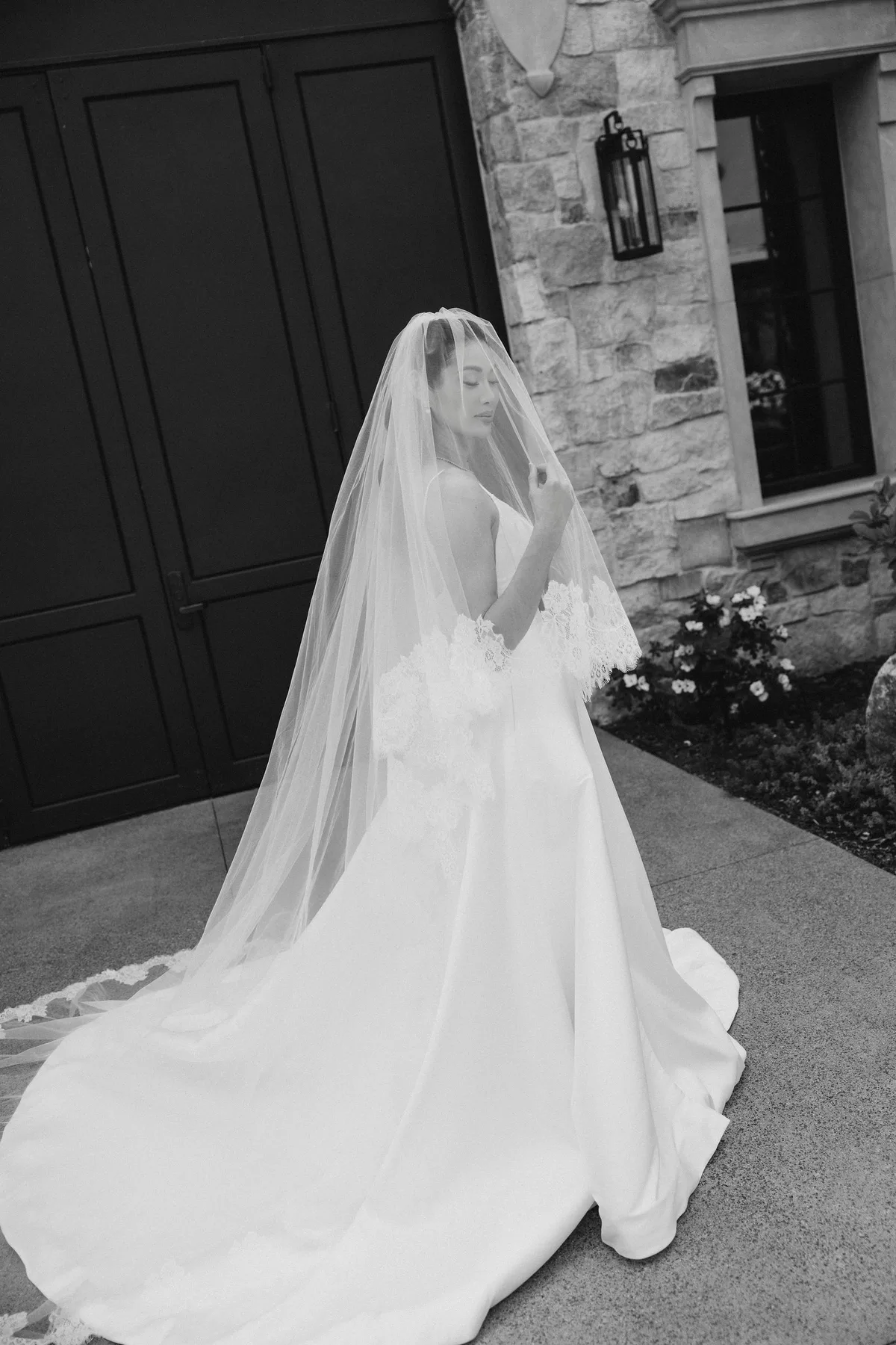 The bride outside the winery doors, her veil and train laid out behind her