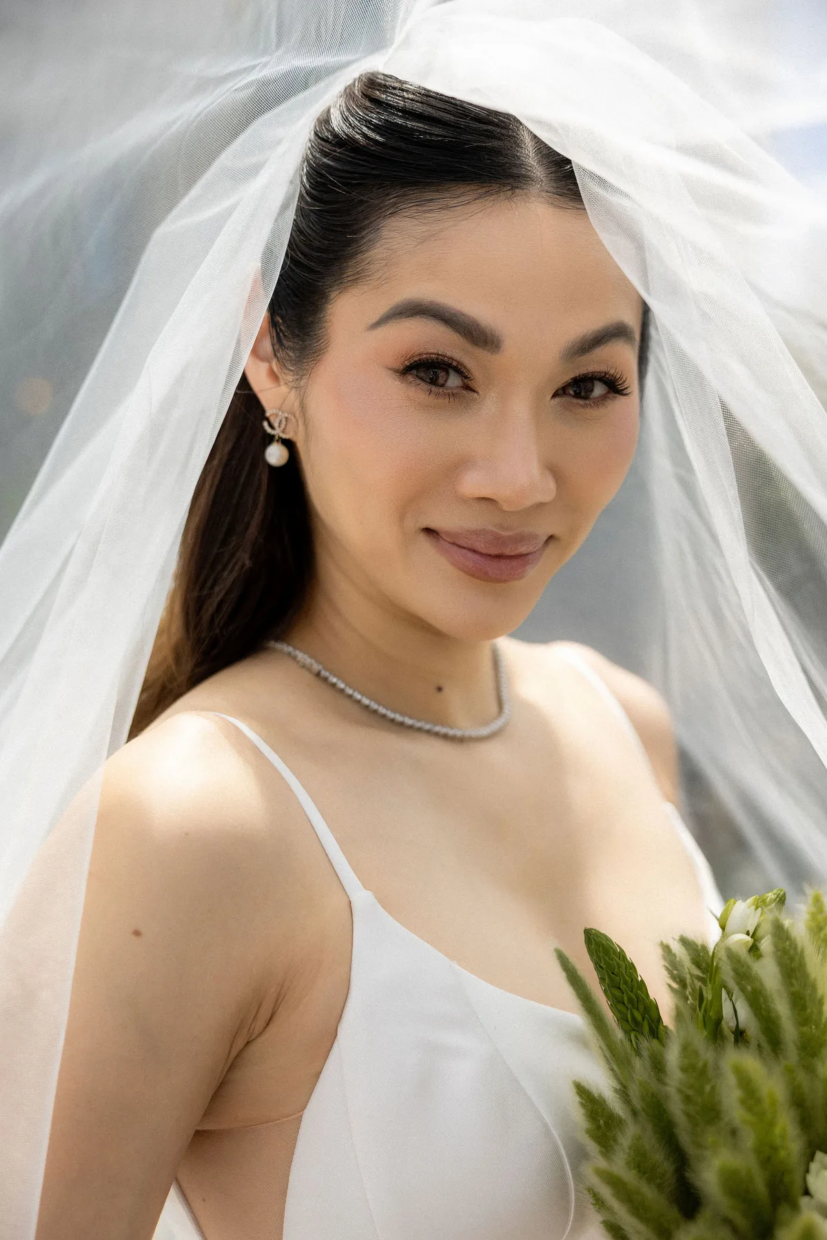 The bride looking to camera from under her veil, close