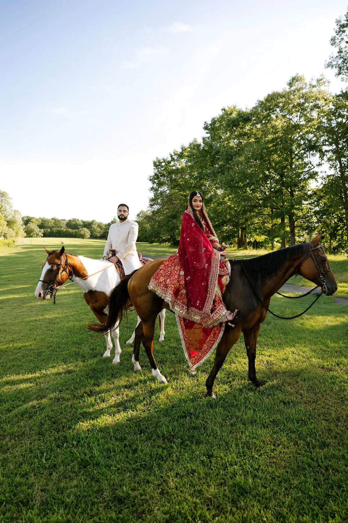 The couple riding out across the grass, the groom on a second horse