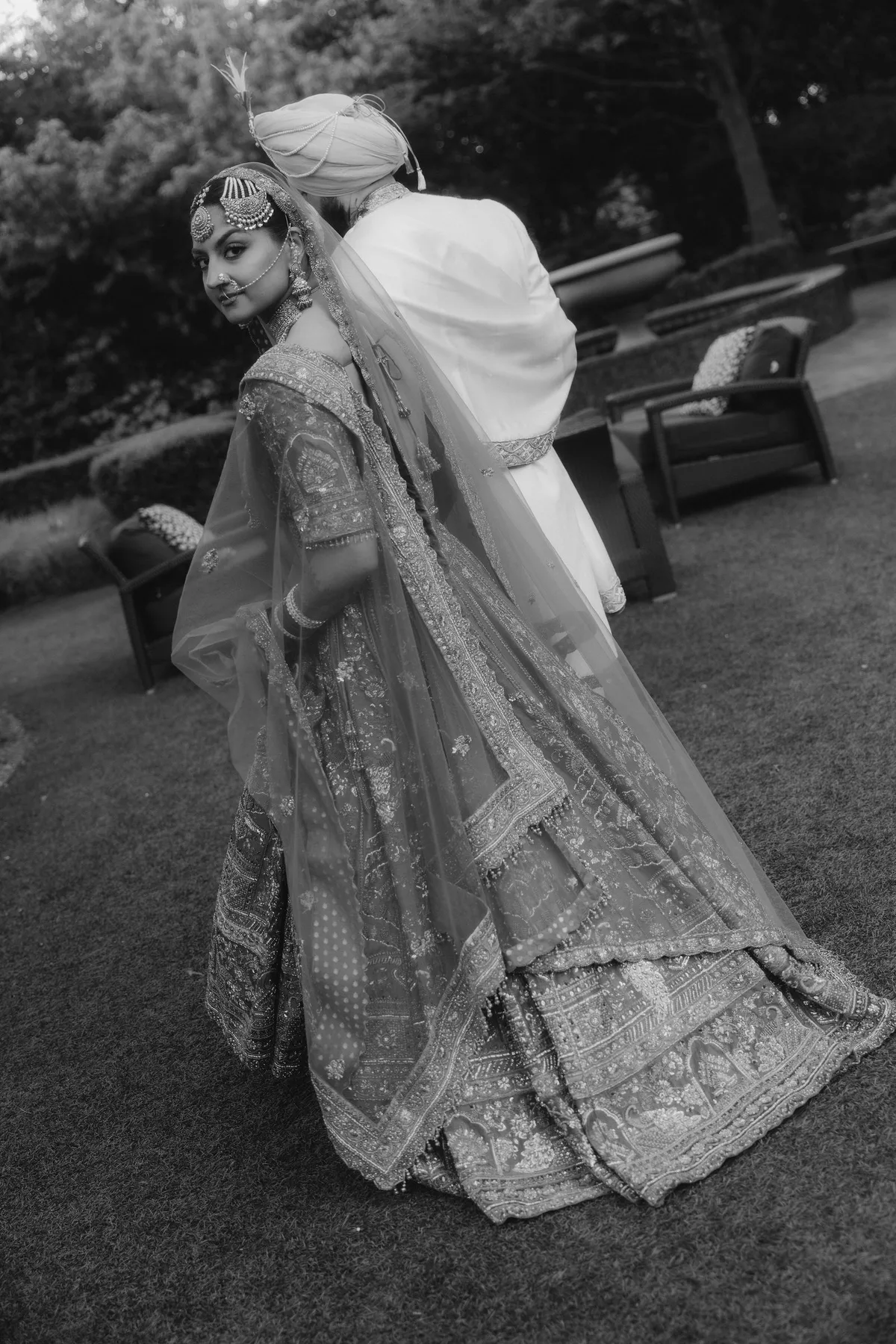The bride turning to camera, her embroidered dupatta sweeping behind