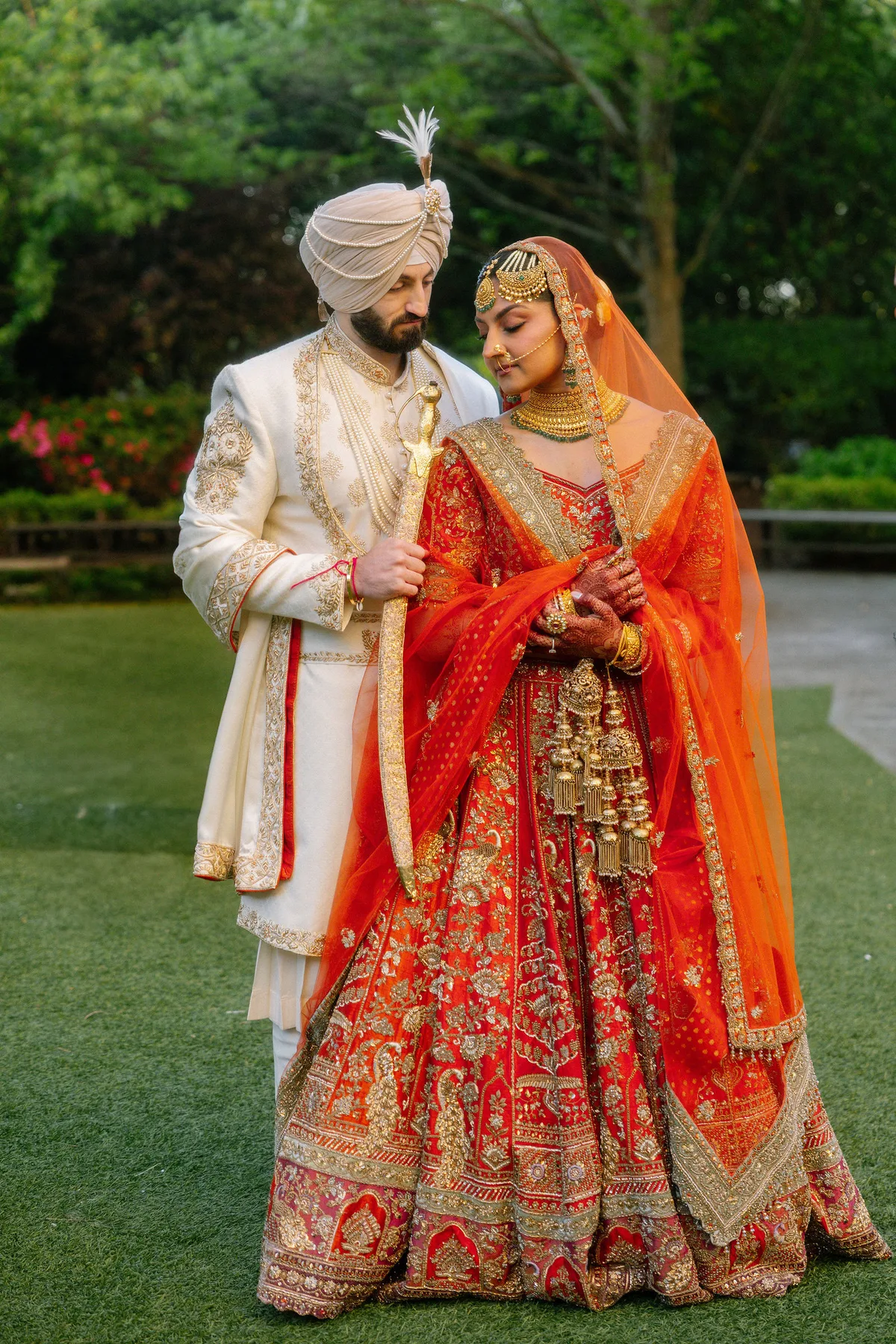 The couple together on the lawn, the groom in a turban and sherwani