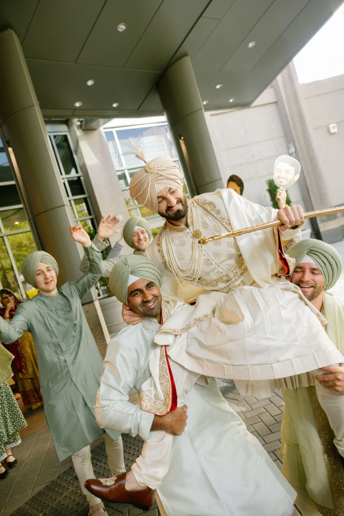 The groom carried shoulder-high by his friends, all in turbans
