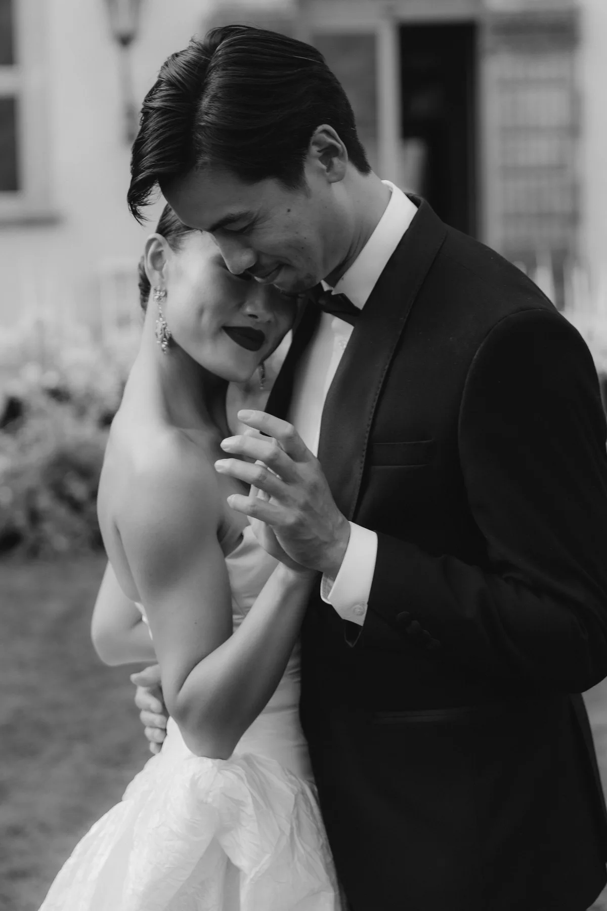 The groom's head bowed to the bride's, her eyes closed