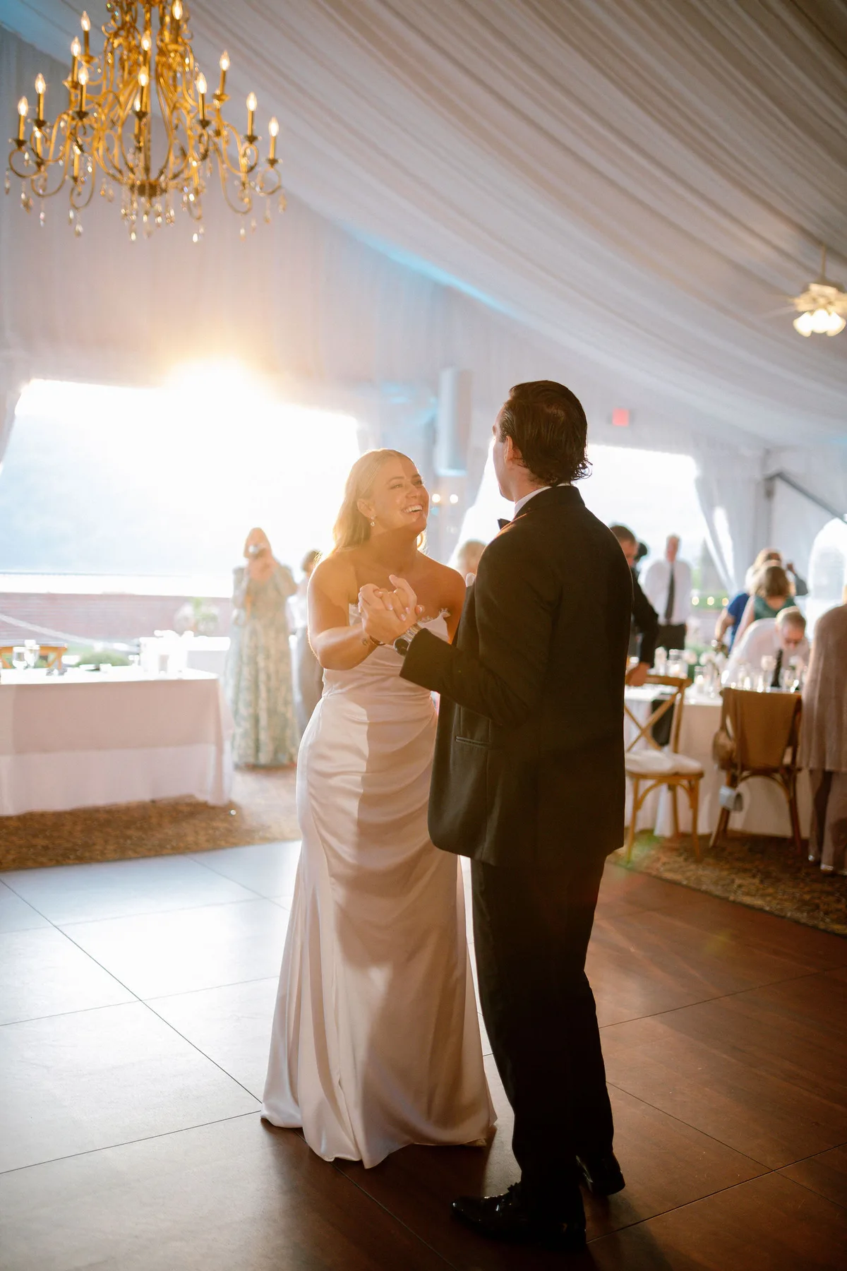 A couple's first dance under a marquee, in the last of the light