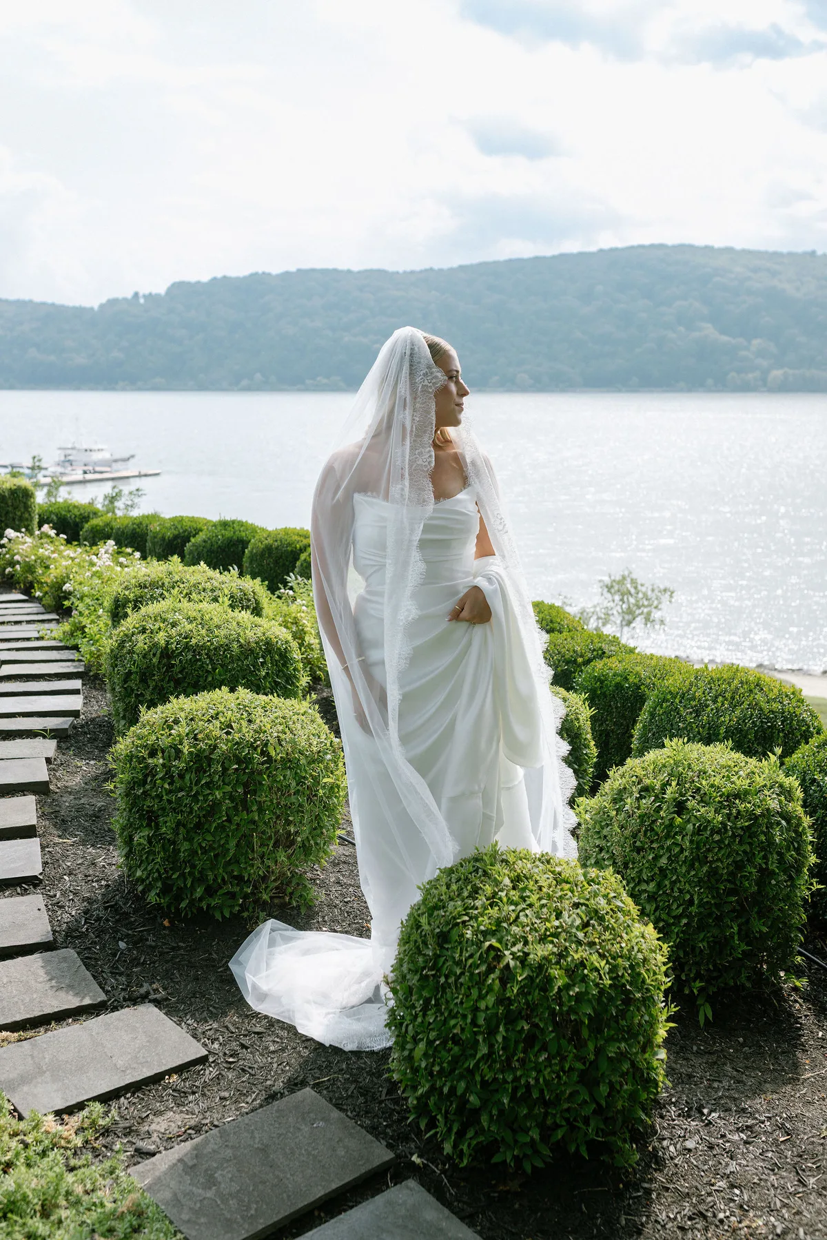 The bride among clipped box on a path above the river